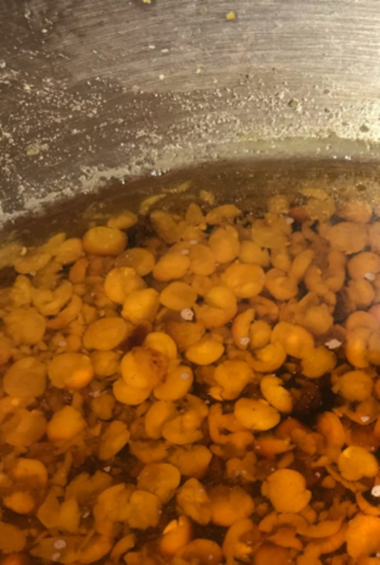 Partly burned lentils in the bottom of an aluminium pan