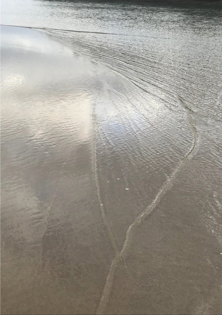 Water rising over sand as the tide enters an estuary
